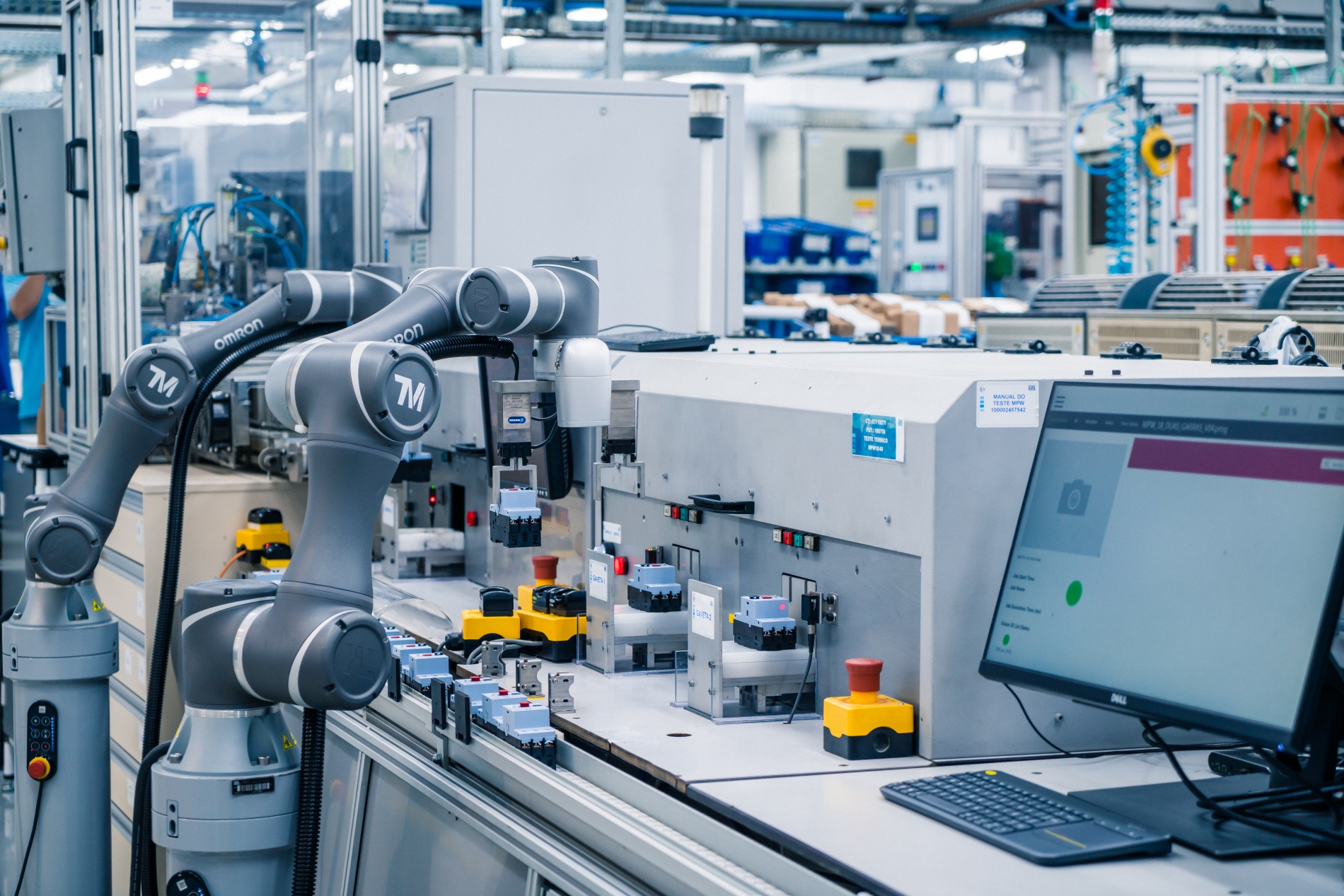 Technician configuring a VFD control panel for AC motors in a factory.