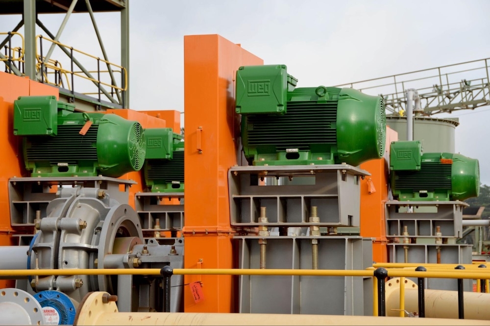 Green industrial electric motors installed on top of an industrial facility.