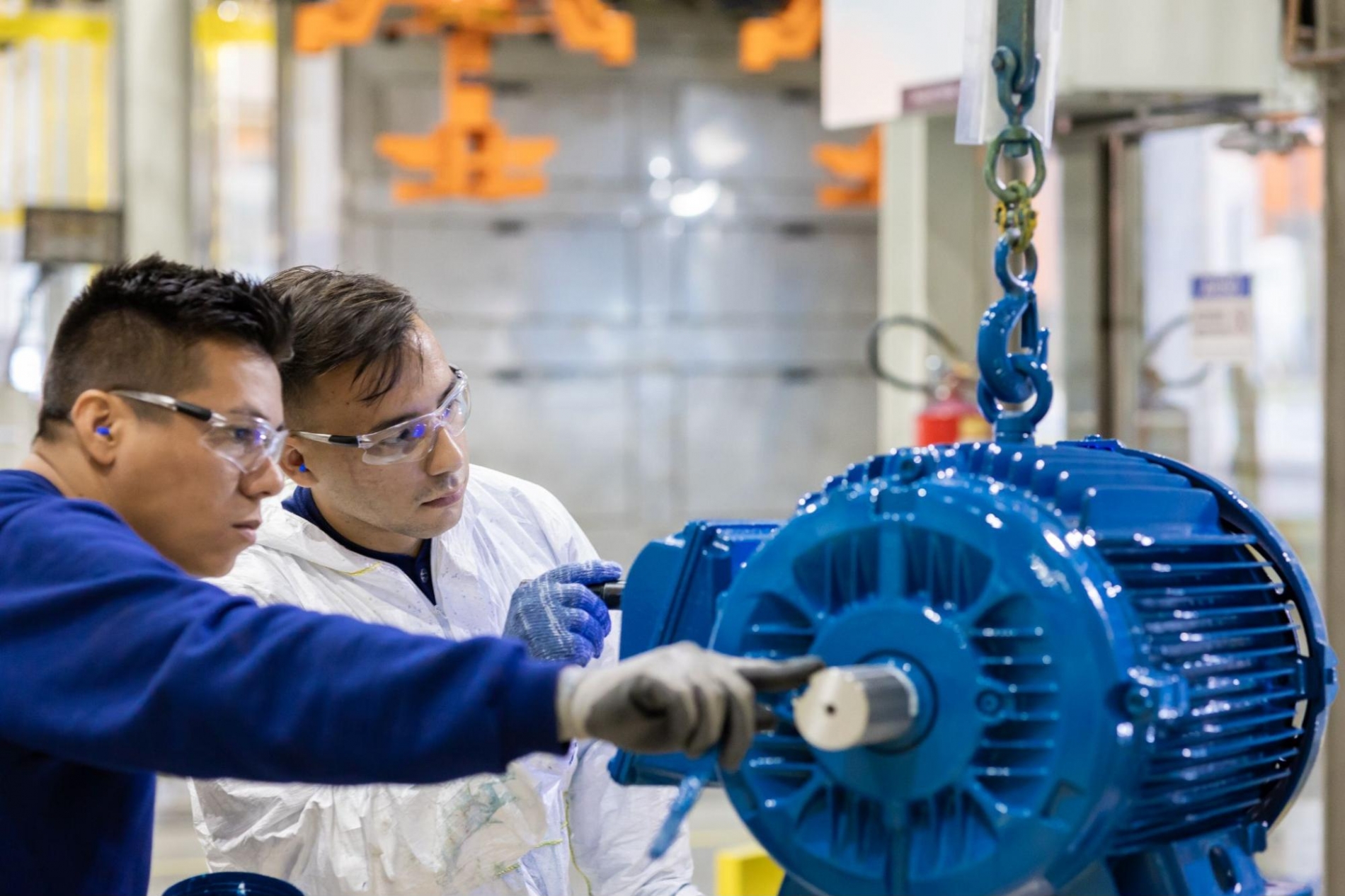 Engineers inspecting a high-efficiency induction motor in a Calgary industrial facility.