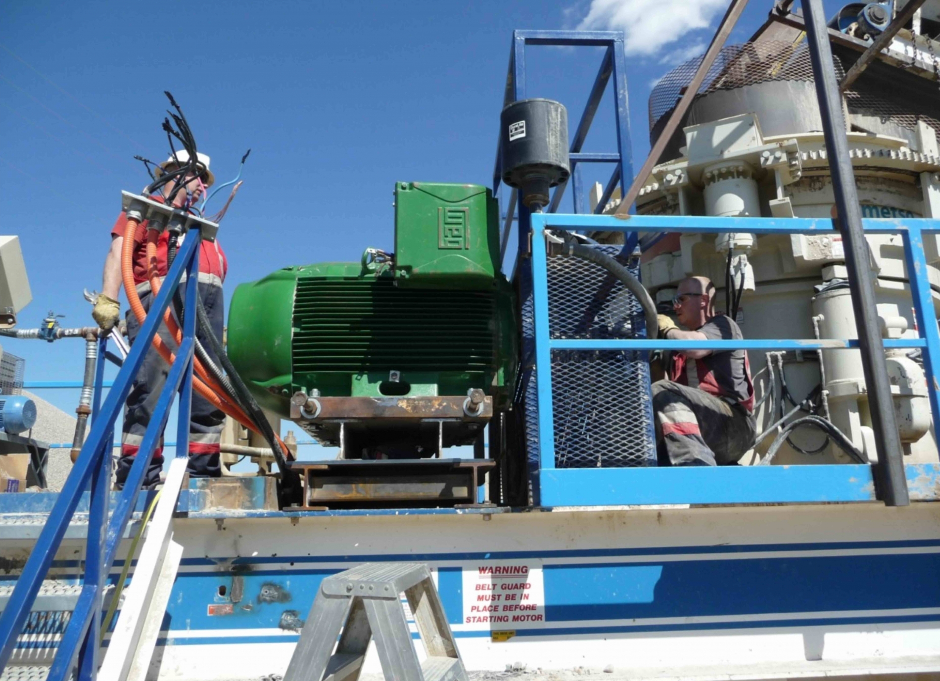 Technicians are seen installing an industrial electric motor at an energy sector facility in Calgary.