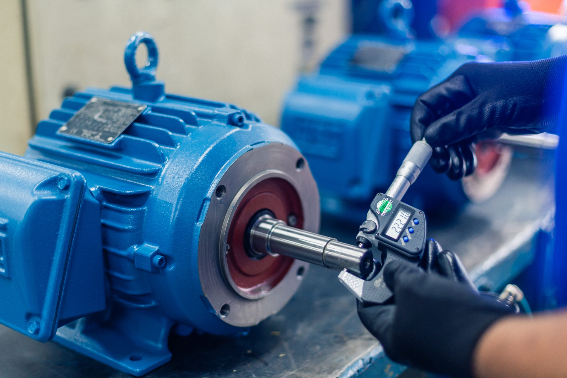 Technician inspecting a WEG motor shaft for early signs of bearing wear and damage.