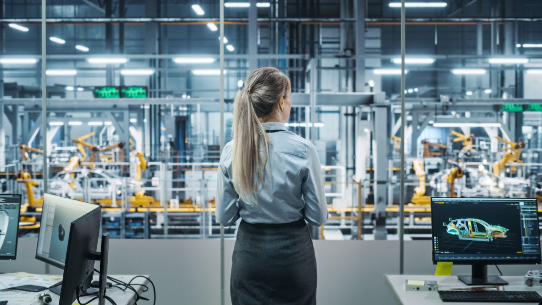 Female leader in industrial automation (Pamensky WEG Canada) examining an industrial assembly line for vehicles.