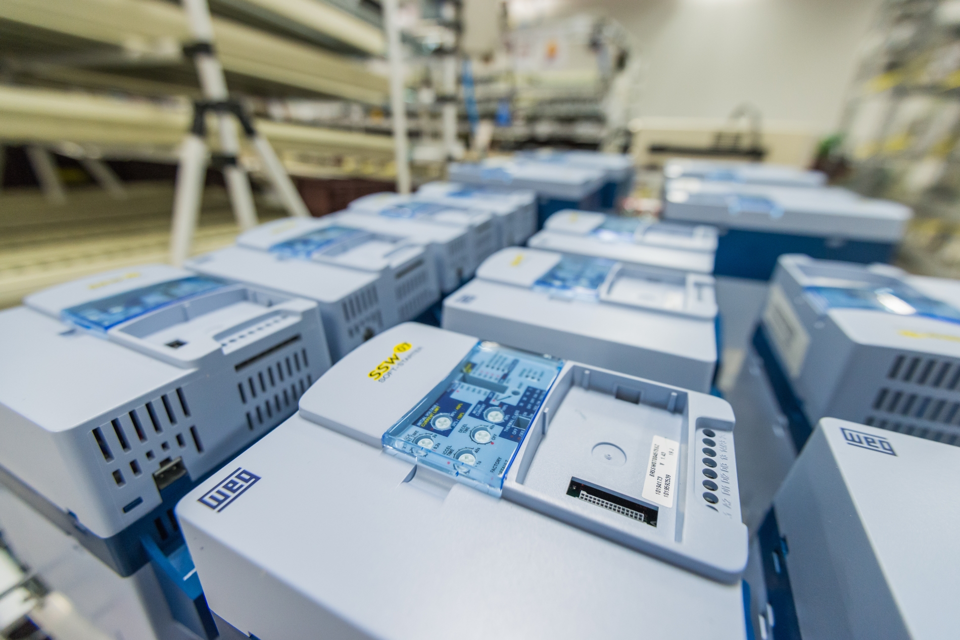 Multiple WEG SSW07 soft starter units organized on an assembly bench in an industrial setting.
