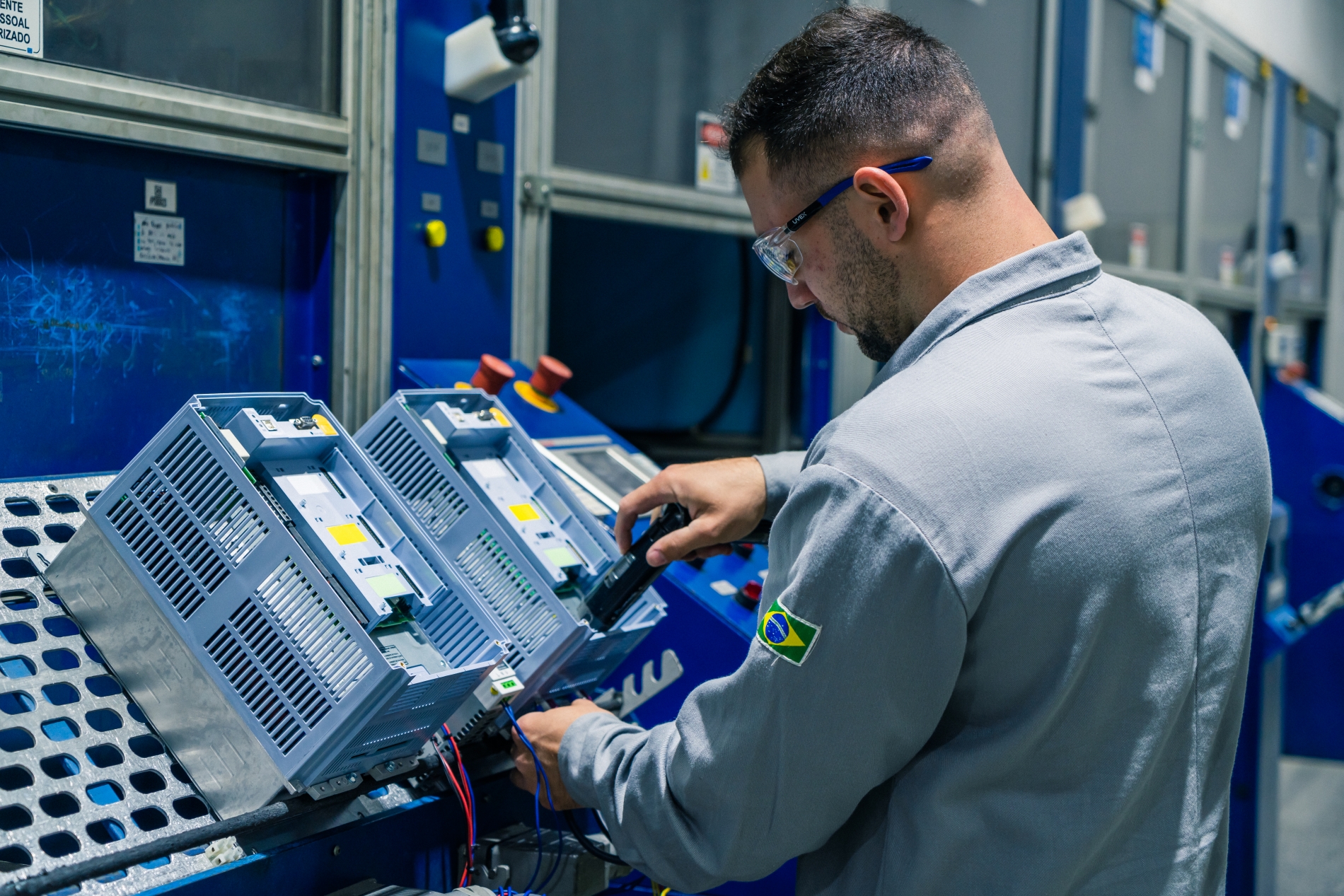 A Variable Frequency Drive (VFD)  installed in an industrial setting, with a technician standing beside it.