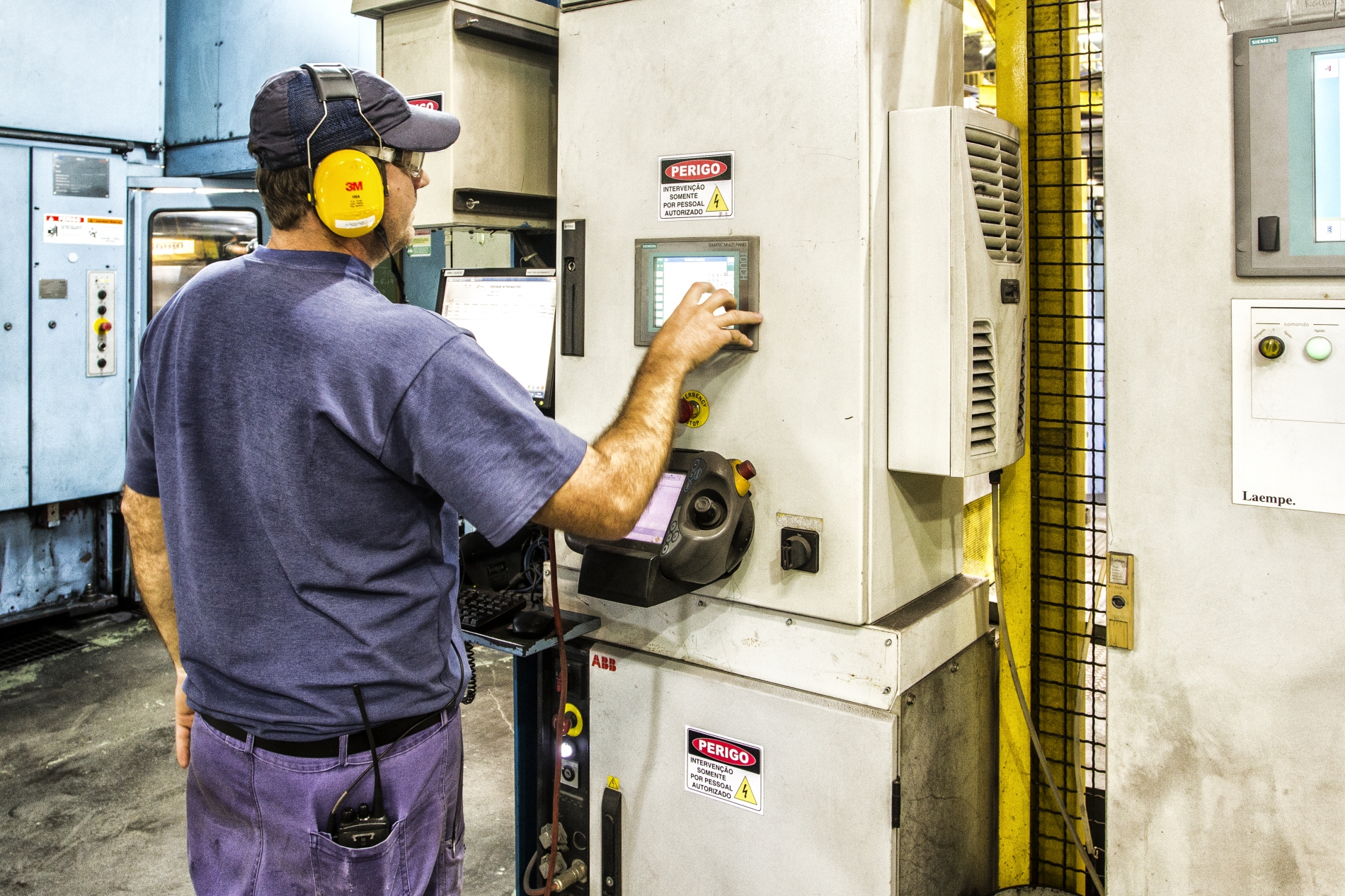 Industrial technician operating control panel for routine motor diagnostics and monitoring.