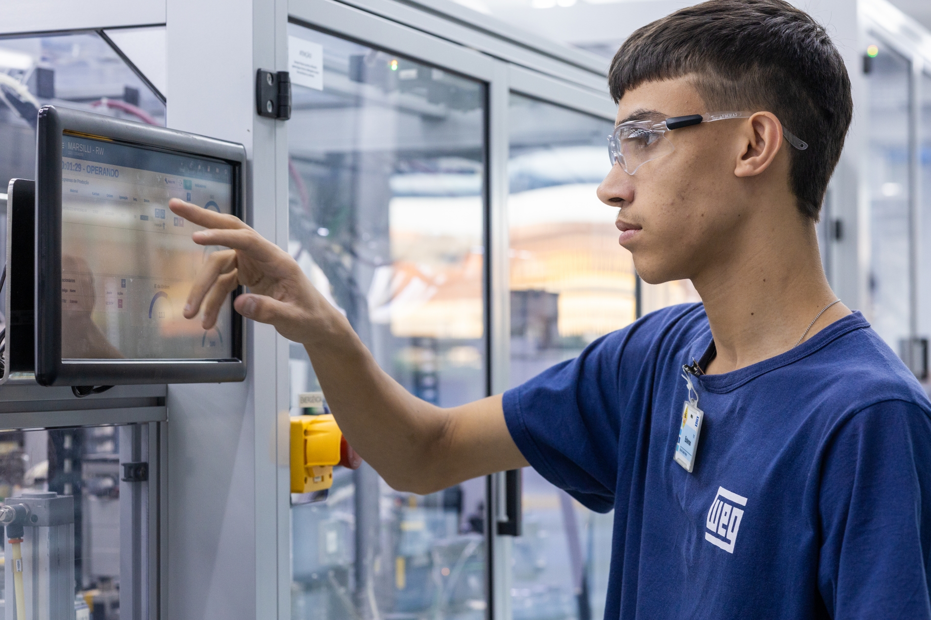 Technician operating a Variable Frequency Drive (VFD) control panel for real-time motor system monitoring.