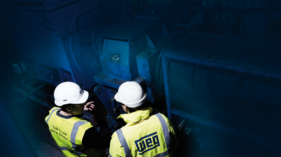 Workers inspecting electric motors at a factory.