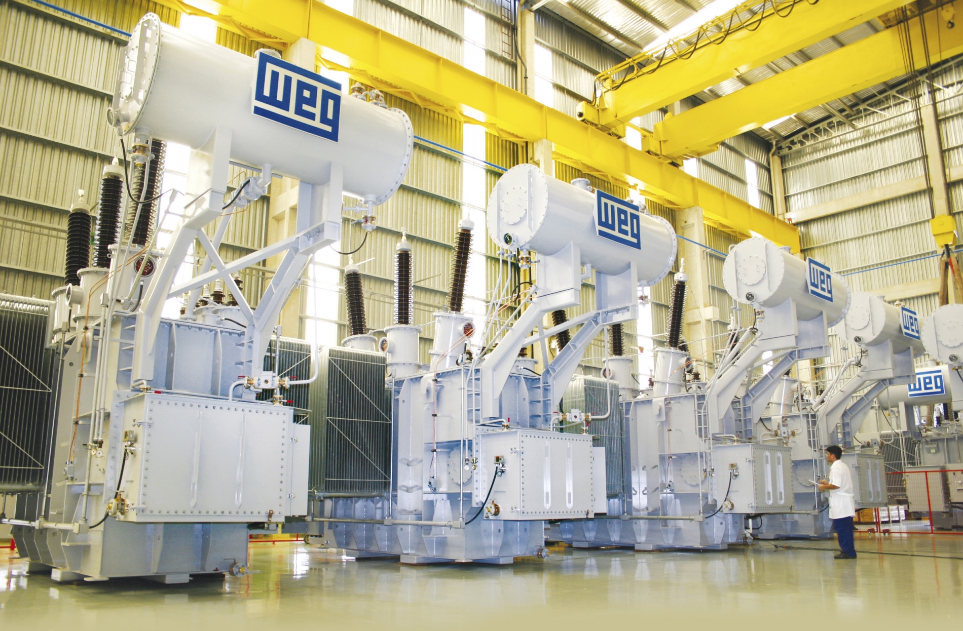 Large WEG-branded industrial transformers in a manufacturing facility, showcasing robust and high-quality equipment for heavy-duty applications.