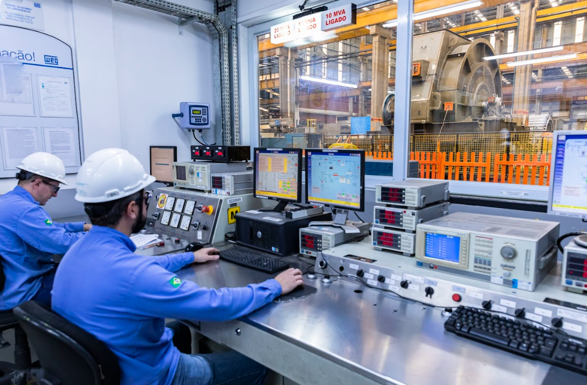 Engineers monitoring an automated motor testing system, ensuring performance and precision in an industrial control room.