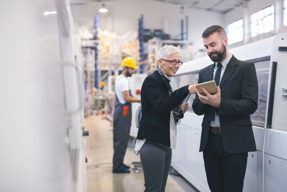 Electric motor distributor going over product description with a factory owner.