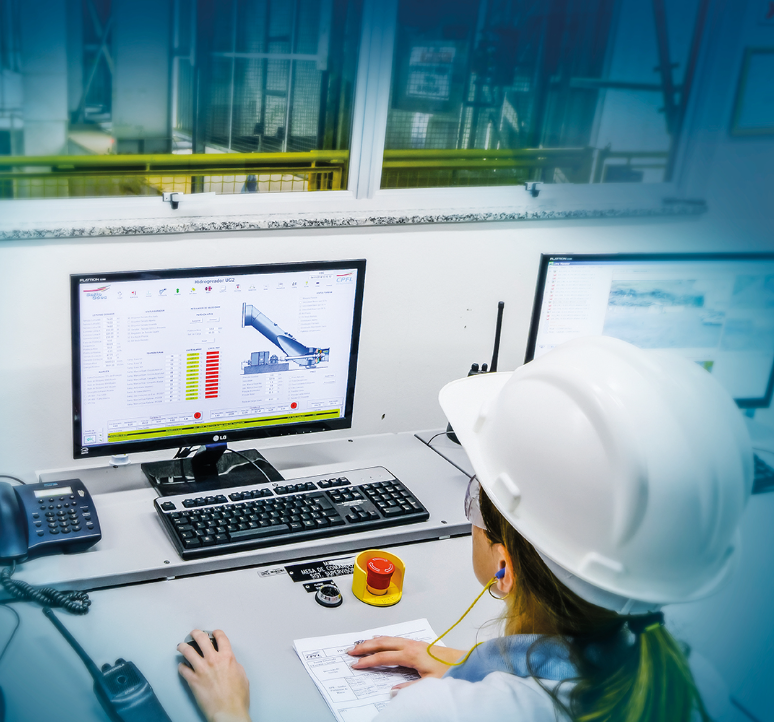 Woman working at a computer in a factory that contains the industrial automation system.