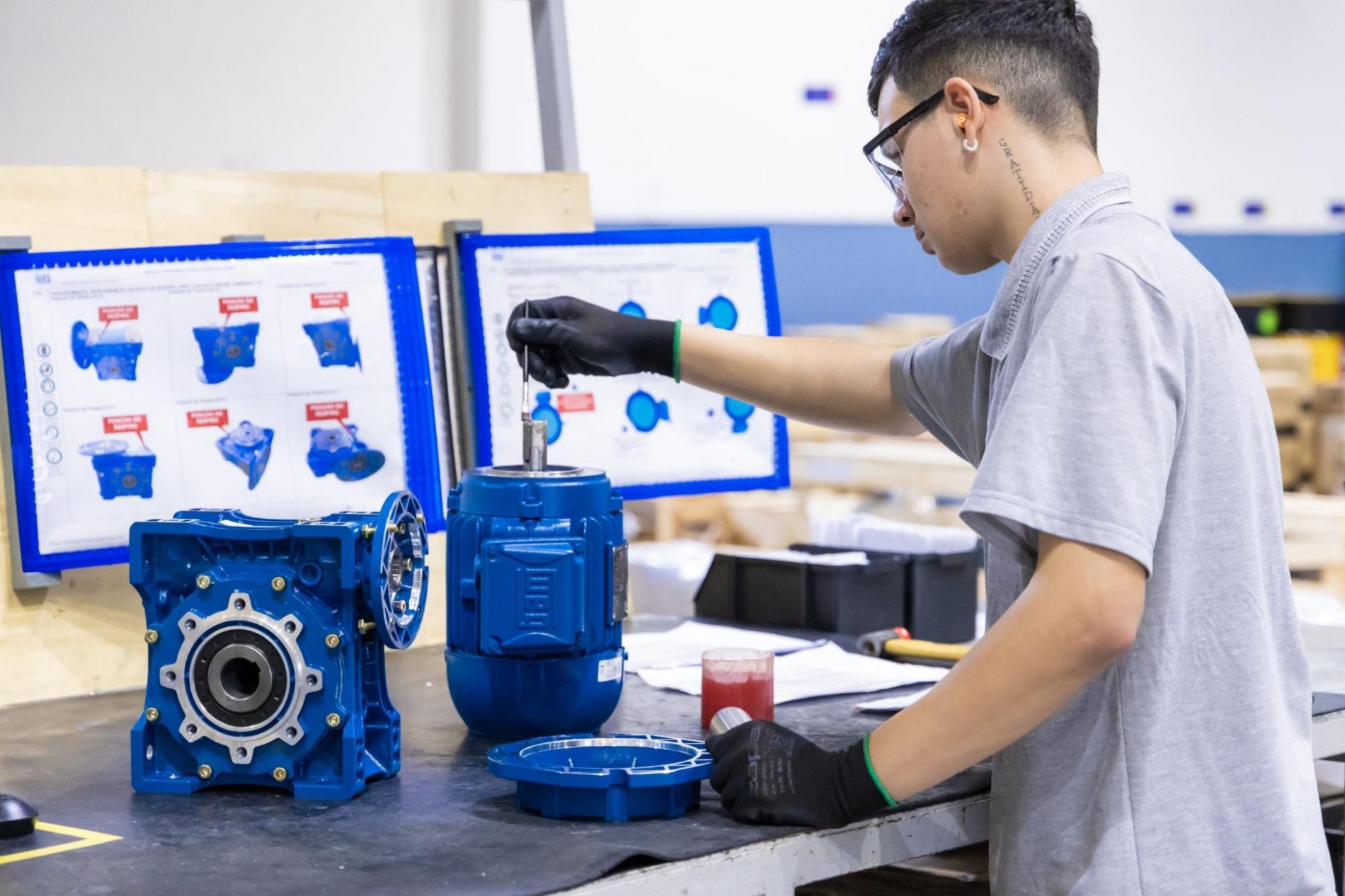 Technician reviewing industrial electric motor enclosure type before installation on the facility floor.