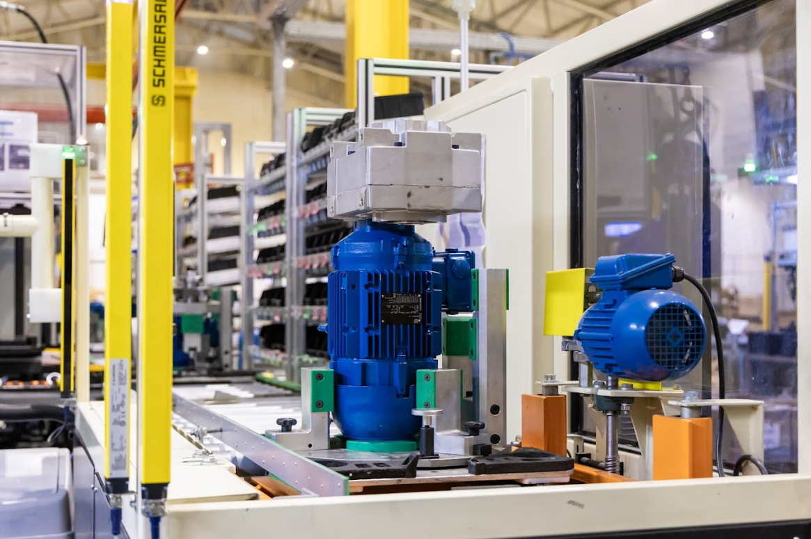 A WEG electric motor mounted on a metal frame with safety barriers and control equipment in the background.