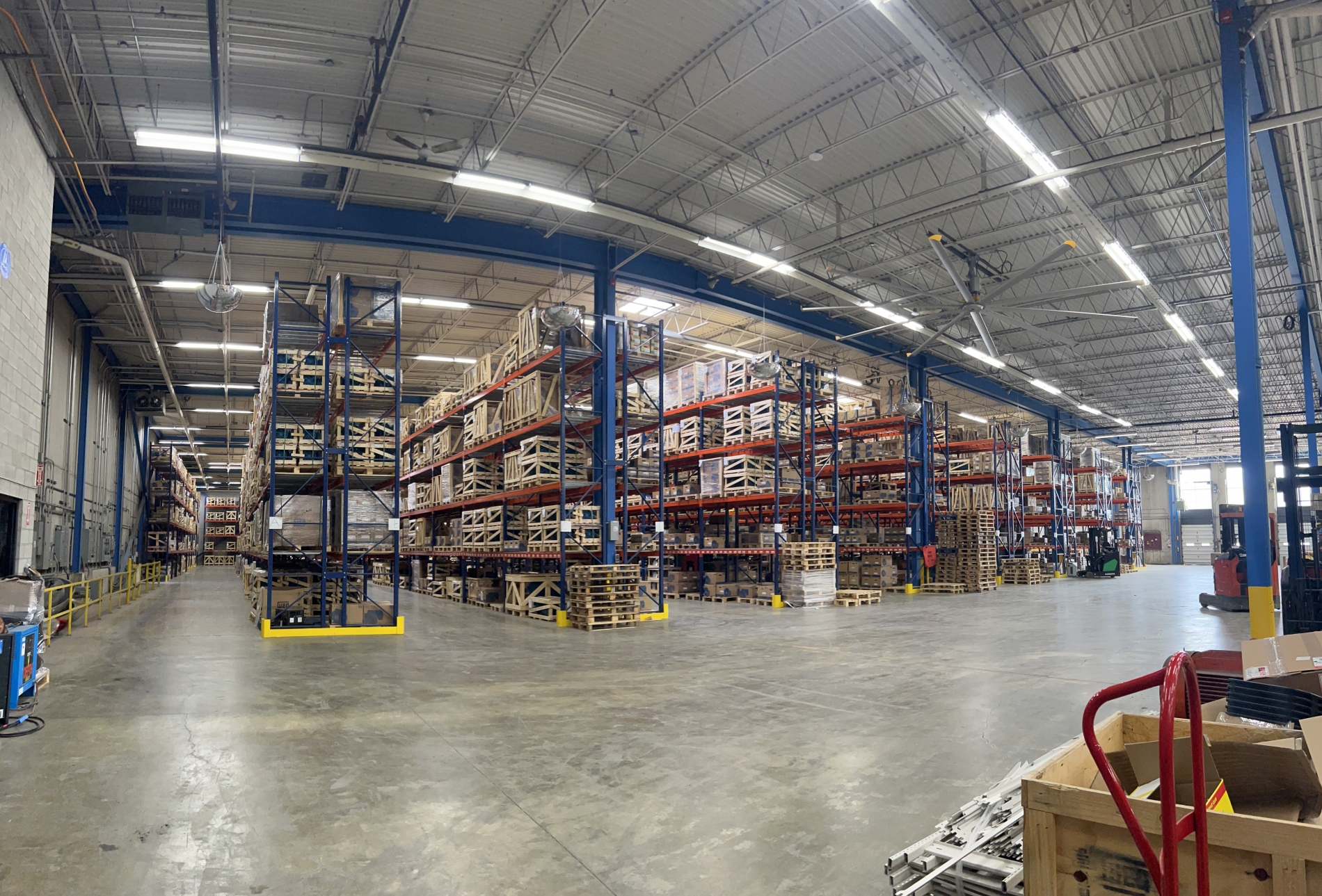 Inside V.J. Pamenskys impressive new facility, spanning over 125,000 sqft in total, with a spacious warehouse showcasing organized shelves stocked with industrial motors and components, representing enhanced operations and inventory management.