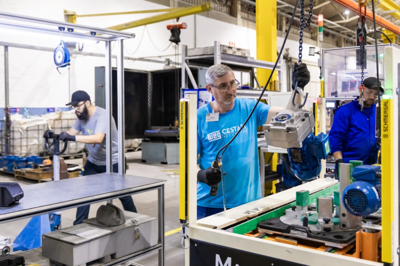 An engineer assembles a WEG Cestari gearbox in an industrial facility showcasing durable components and manufacturing quality.