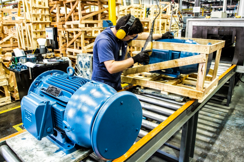 High-efficiency industrial electric motor positioned on a factory floor, showcasing heavy-duty design and energy-saving potential.